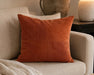 Coussin décoratif JULES en velours rouille posé sur un sofa beige