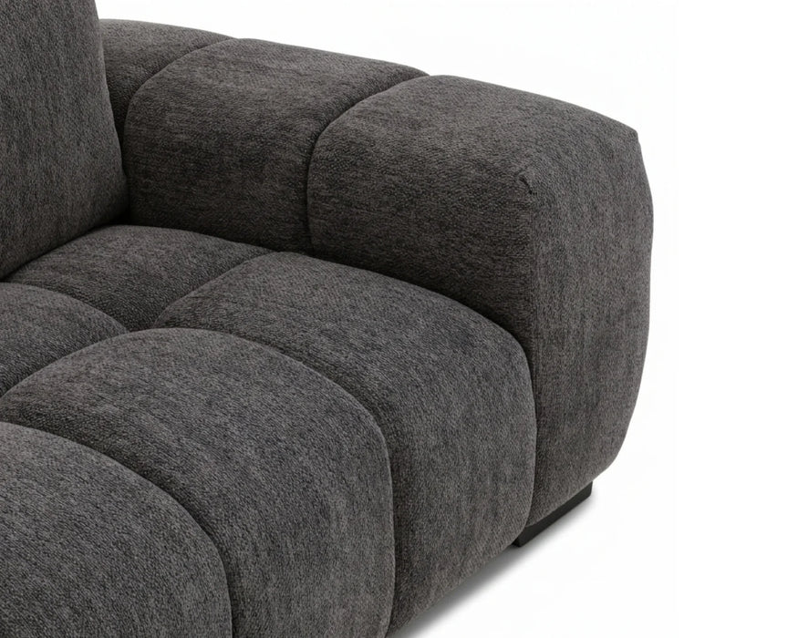 Gros plan sur l'assise et l'accoudoir du divan OLIVIA gris foncé